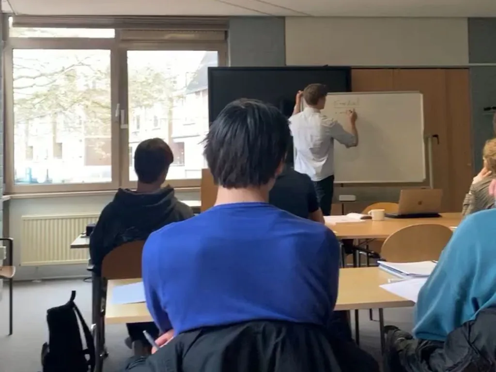 Een examentraining van BES Examenhulp op school: een trainer schrijft op het whiteboard, leerlingen kijken mee.